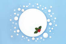 Christmas Dinner Plate Table Place Setting With Holly Red Berries And White Frosted Decorations. Abstract Minimal Design For Xmas Festive Holiday Season And New Year. On Pastel Blue.