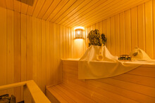 Interior Of A Wooden Sauna With Traditional Accessories. The Original Lamp In The Corner.