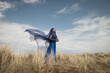 © Milou Dirks - fine art portrait of woman in blue dress standing in dunes  coverd by thin fabric