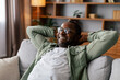 Satisfied adult african american man in glasses and casual resting and relaxing, enjoy comfort, peace and free time