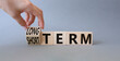 Long term vs Short Term symbol. Businessman hand turnes wooden cubes and changes words Short term to Long Term. Beautiful grey background. Business concept. Copy space.