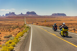 Fototapeta  - Classic panorama view of motorcyclist on historic U.S. Route 163 running through famous Monument Valley, Utah, USA