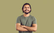 © Studio Romantic - Portrait of happy young indian man with beautiful smile on khaki studio background. Bearded ethnic guy in dark green T-shirt with folded arms smiles confidently looking at camera. Banner.