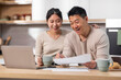 © Prostock-studio - happy asian couple paying bills on Internet, using laptop