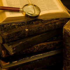 old books on the table, reading by candlelight, magnifier