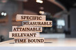 Wooden blocks with words 'Specific, Measurable, Attainable, Relevant, Time bound'. SMART