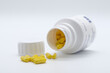 Pills in yellow color with pills can on white background, medicine, cropped image