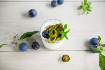 Wall Mural - sweet homemade yogurt with fresh plum slices in a glass