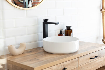 Black faucet for water and white separate high sink on wooden pedestal. Loft style bathroom