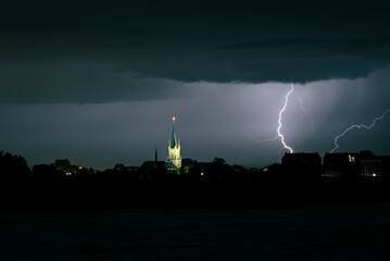 Wall Mural - lightning bolt strikes close to an illuminated church