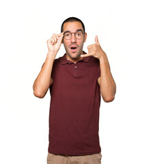 Amazed young man making a gesture of calling with the hand