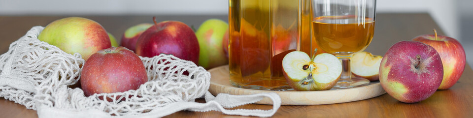 Wall Mural - Fresh homemade organic apple juice or cider on a wooden table in a glass jug. Banner copy space