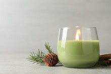 Composition With Burning Candle And Pinecone On Light Grey Table, Space For Text