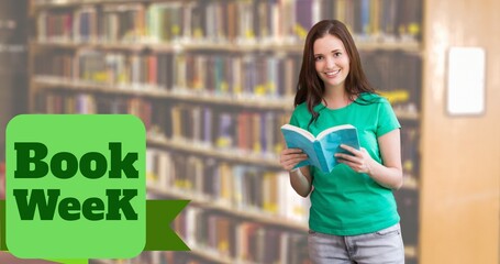 Poster - Book week text over portrait of smiling caucasian teenage girl with book standing in library
