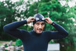 © Westend61 - Man wearing wetsuit adjusting swimming goggles