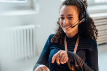 Happy Customer Service Representative Talking Through Headset In Office