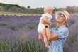 Happy mother with little daughter on lavender background. Family holiday in summer day.