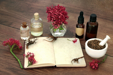 Wall Mural - Valerian herb root with essential oil bottles, flowers, notebook. Alternative herbal adaptogen plant medicine to treat, anxiety, insomnia, headaches, menopause, digestive problems.