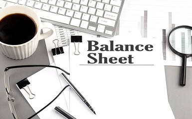 Poster - BALANCE SHEET text on a paper with magnifier, coffee and keyboard on grey background