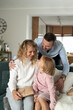 © gpointstudio - Vertical image of  caucasian family of parents and girl sitting and holding Christmas presents