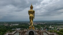 Golden Big Buddha Statue Standing On Hill With City At Wat Phra That Kao Noi, Nan, Thailand
