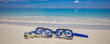 Summer sport, beach activity, beach recreational concept. Diving goggles snorkel gear on white sand near sea waves. Summer vacation and recreational travel background. Fun freedom adventure lifestyle