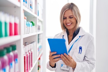 Canvas Print - Young blonde woman pharmacist using touchpad working at pharmacy