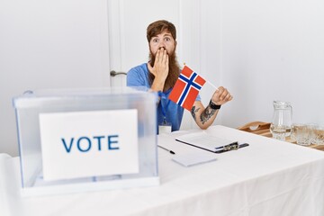 Poster - Caucasian man with long beard at political campaign election holding norwegian flag covering mouth with hand, shocked and afraid for mistake. surprised expression