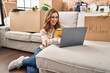 © Krakenimages.com - Young woman drinking coffee using laptop at new home