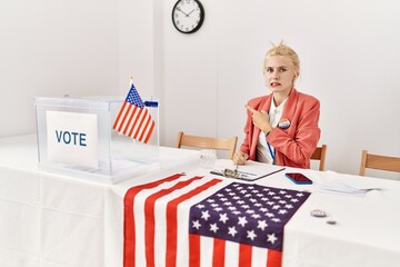 Poster - Beautiful caucasian woman working at political campaign pointing aside worried and nervous with forefinger, concerned and surprised expression