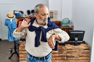 Sticker - Handsome senior man holding shopping bags at boutique shop checking the time on wrist watch, relaxed and confident