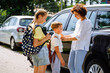 © Iryna - Single mother saying goodbye to her two children at ar parking outdoor, near school. Single mom, school, family, education outdoor concept.