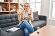 © Krakenimages.com - Young woman working at consultation office afraid and terrified with fear expression stop gesture with hands, shouting in shock. panic concept.
