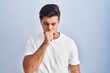 © Krakenimages.com - Hispanic man standing over blue background feeling unwell and coughing as symptom for cold or bronchitis. health care concept.