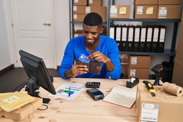 Sticker - Young african american man ecommerce business worker holding wallet with credit card at office