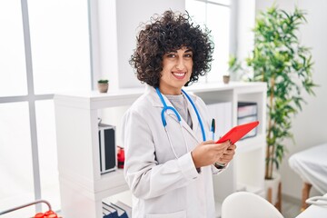 Wall Mural - Young middle east woman wearing doctor uniform using touchpad at clinic