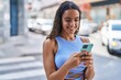 © Krakenimages.com - Young beautiful hispanic woman smiling confident using smartphone at street