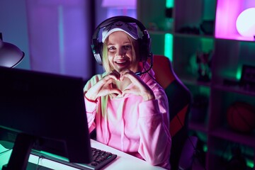 Canvas Print - Young blonde woman streamer smiling confident doing heart symbol with hands at gaming room