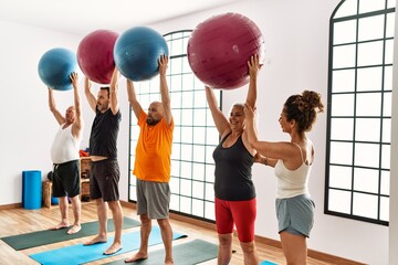 Sticker - Group of middle age people training using fit ball with personal trainer at sport center.