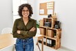 © Krakenimages.com - Young hispanic woman smiling confident standing with arms crossed gesture at office
