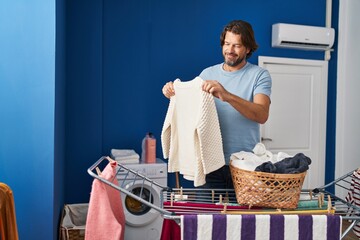 Wall Mural - Middle age man smiling confident hanging clothes on clothesline at laundry room