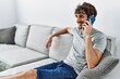 © Krakenimages.com - Young hispanic man smiling confident talking on thesmartphone at home
