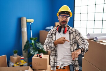 Wall Mural - Young hispanic man with beard working at home renovation in hurry pointing to watch time, impatience, upset and angry for deadline delay