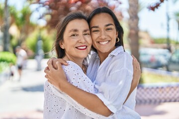 two women mother and daughter smiling confident hugging each other at park
