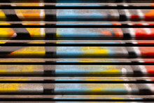 Colorful Structures Made By Street Artists. Macro Close Up Of Details Of Graffiti Image In Yellow, Red And Blue On A Metal Roller Shutter In Naples Italy With Bright Side Light. Abstract Background.