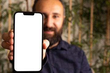 Showing modern smartphone, portrait of caucasian bearded man showing modern smartphone. Selective focus on hand. Mobile phone mock up with white blank screen. Application recommend concept photo idea.