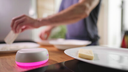 Empty light base hologram with person in background cooking in kitchen