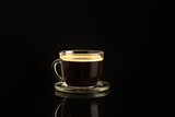 Glass cup of fresh aromatic coffee on a dark background