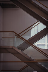 Wall Mural - Side view of metal and glass stairs inside the building with sunlight shine through round window glass. Emergency exit by a stairwell in a Modern building. Selective Focus.