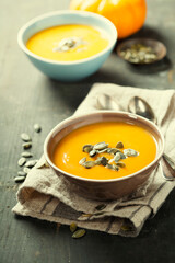 Wall Mural - Pumpkin soup in a bowl on a wooden surface with copy space